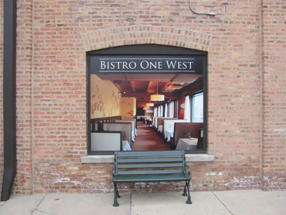 A bench in front of a restaurant sign, capturing the inviting vibe in St. Charles, IL.